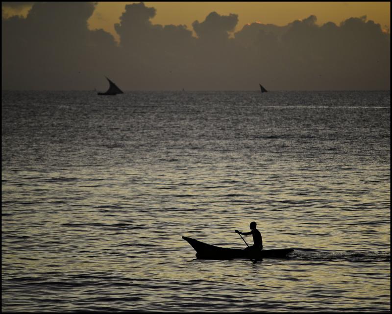 Fisherman taking his dugout canoe out at dawn, Dar es Salaam, Tanzania
